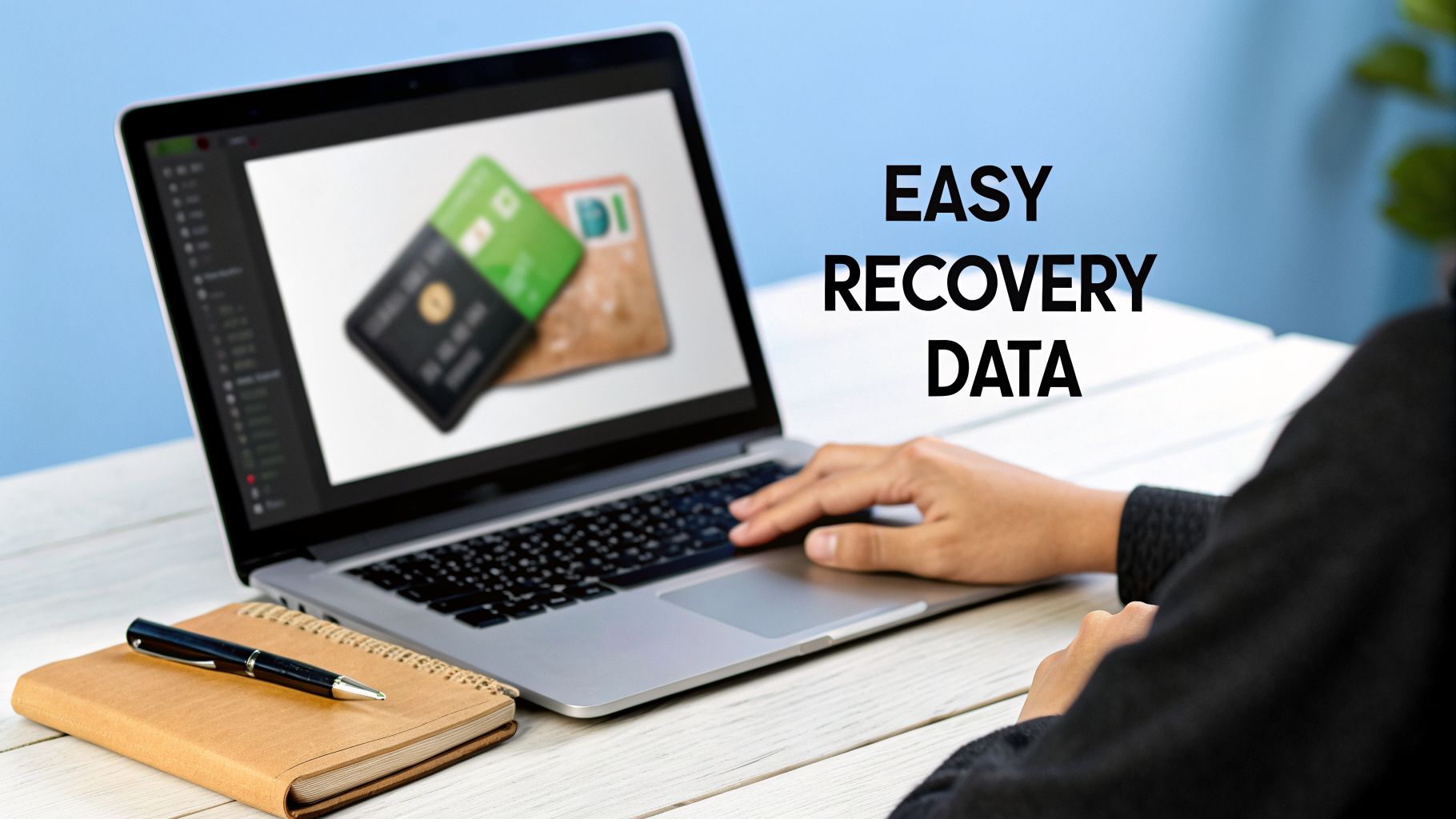 A person typing on a laptop displaying credit cards, with a notebook and pen nearby, advertising 'EASY RECOVERY DATA'.